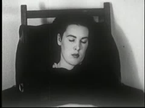 Woman wakes up in a chair, opening her eyes.