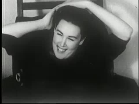 Woman in a chair stretches her arms and smiles.