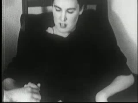 Woman sits at a table and takes a pencil from a hand.