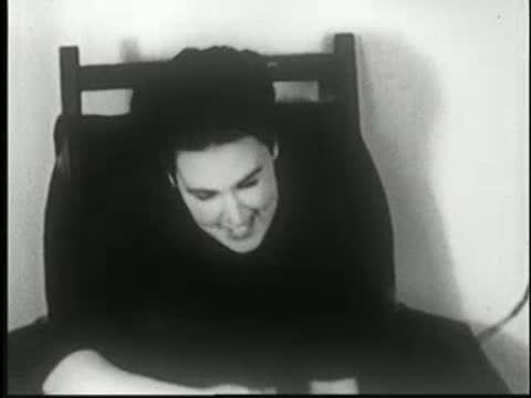 Woman wakes up in a chair, smiling and opening her eyes.