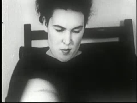 A person reading a magazine, showing subtle facial expressions, black-and-white.