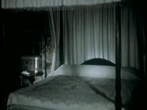 Four-poster bed with canopy in a dimly lit bedroom