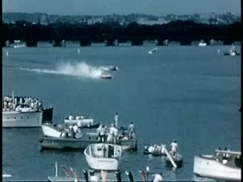 Speedboats racing on a lake with spectators watching from boats, 1940s.