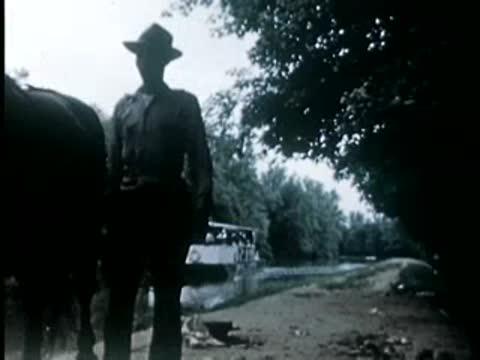 Man with horse on canal towpath, 1940s film style