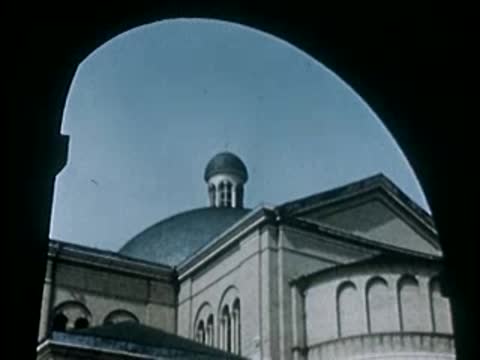 Architectural dome of a large building seen through arch, 1940s film style