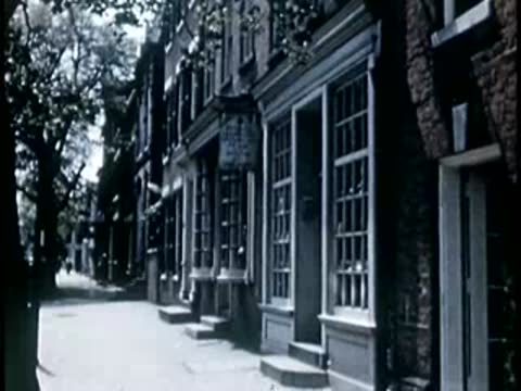 Historic European street lined with traditional buildings, 1940s film style