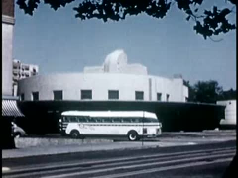 Modern white building and bus on city street, 1940s film style