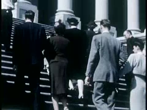 People walking up the large steps of a monument, 1940s film style