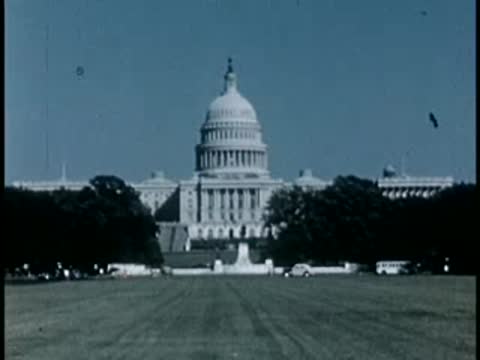 US Capitol building viewed across a wide green lawn, 1940s film style