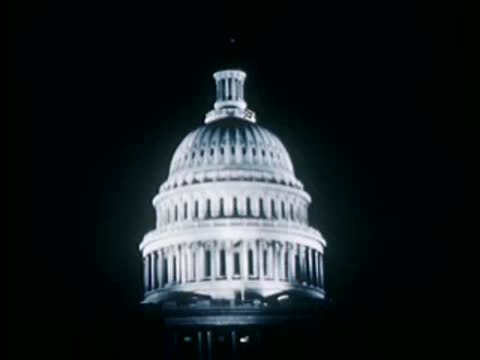 US Capitol dome building against dark background, historical documentary footage.