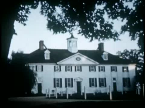 White mansion with cupola viewed across lawn