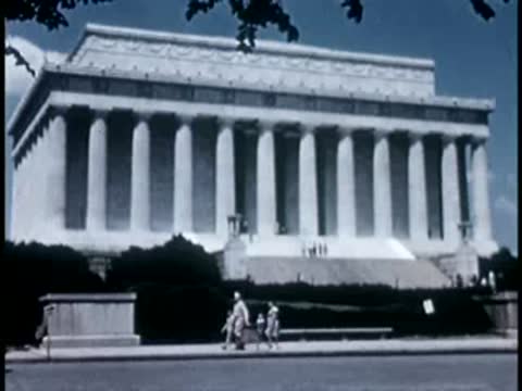 Medium shot of pedestrians walking in front of the Lincoln Memorial, 1940s.