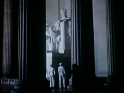 Medium shot inside the Lincoln Memorial looking toward the central statue.