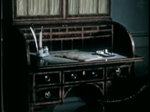 Roll-top wooden desk with inkwell and quills