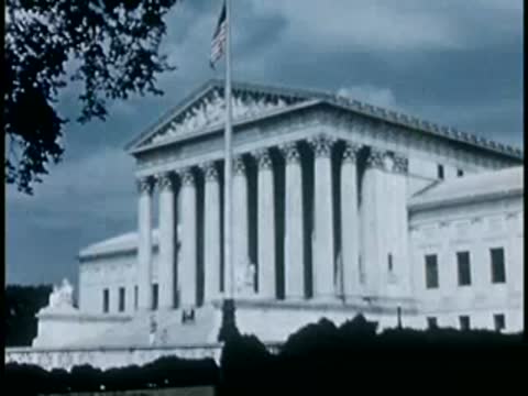 Medium shot of the U.S. Supreme Court building with an American flag flying.