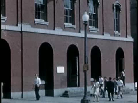 People walking in front of a brick building entrance in Washington D.C.