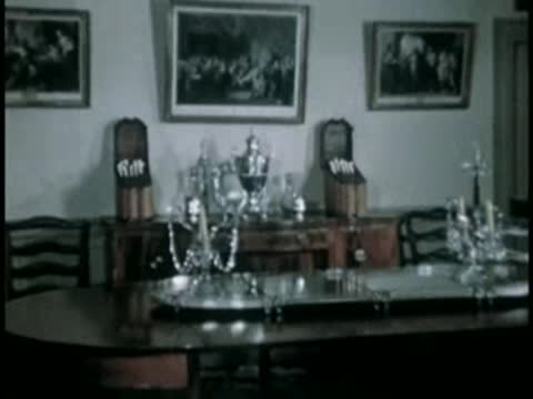 Dining room interior with table settings and framed pictures