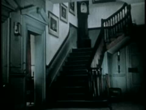 Dark hallway with stairs and wooden staircase banister