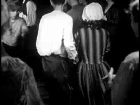 couples folk dancing indoors in a rustic room