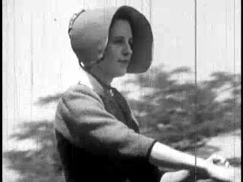 Close-up profile of a woman in a bonnet riding a horse outdoors