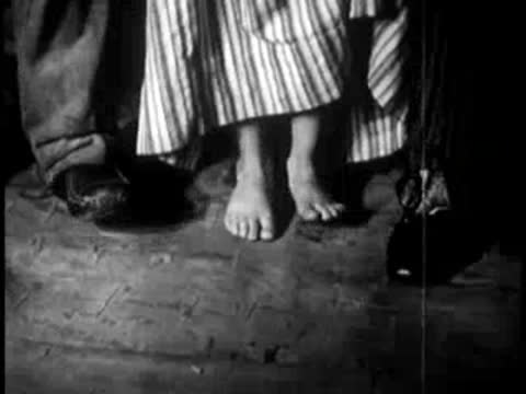 bare feet and skirts of people dancing indoors on wooden floor