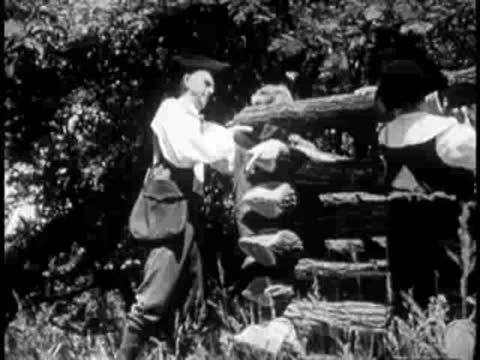 men building a log cabin structure outdoors in the woods