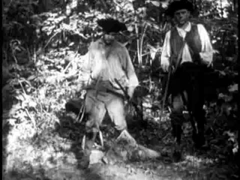 A pioneer working in a wooded area with tools and vegetation