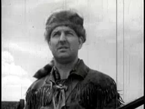 Close-up of a smiling pioneer wearing a fur cap with a tail.