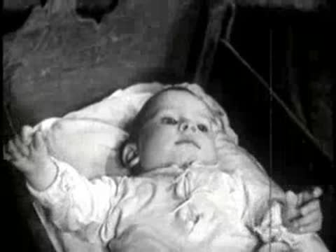 Close-up of an infant lying in a cradle and looking around.
