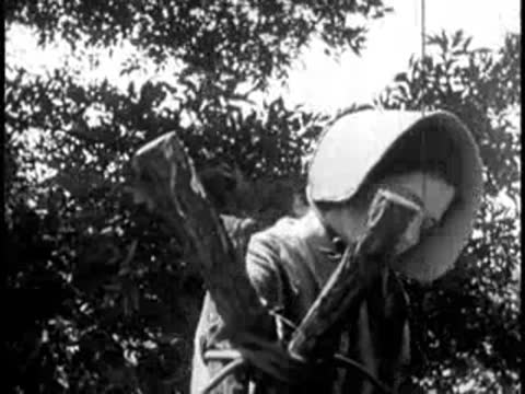 a woman wearing a sunbonnet tending to a steaming outdoor cauldron setup