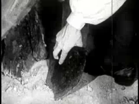 close-up of hands working with a metal tool and wooden block