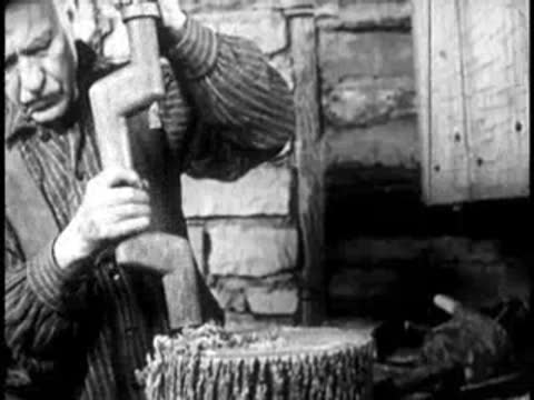 a man operating a wooden press or drill tool on a tree stump