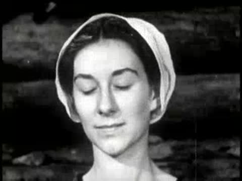 A woman closing her eyes while speaking inside a cabin