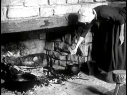 A woman tending a cooking pot over an open fireplace