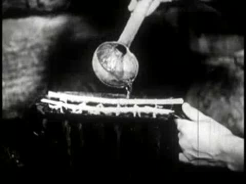 A ladle pouring liquid onto a mold to make candles