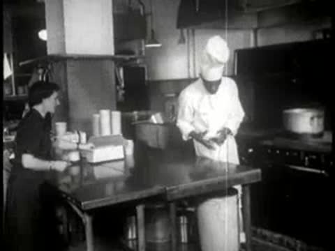 chef working in a restaurant kitchen with staff nearby