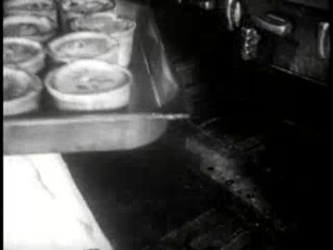 baker taking a tray of freshly baked pies from the oven