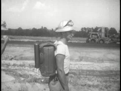 outdoor worker holding a beverage container in a field setting