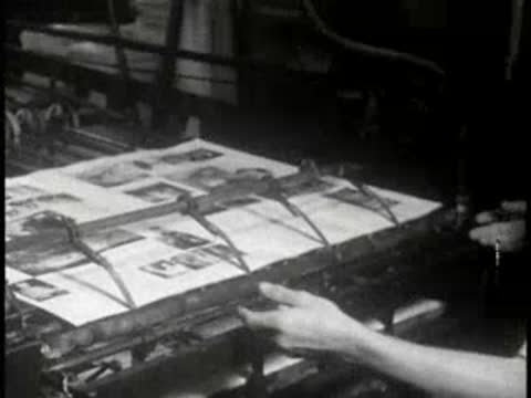 Workers operating printing presses in an industrial facility, mid-century.