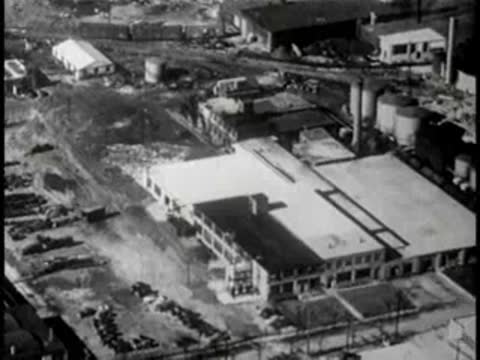 High-angle aerial view of a large industrial plant complex, mid-century.