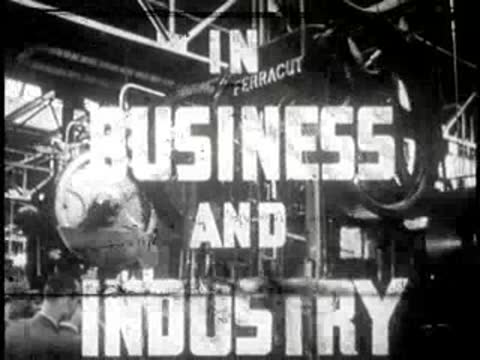 Industrial factory machinery operating inside a large plant, historical footage