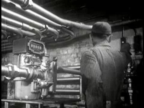 Worker monitoring industrial machinery gauges and pipes, mid-century.