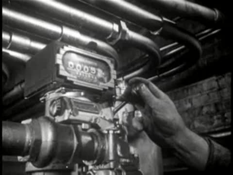 Close-up of industrial gauges and dials on factory machinery, mid-century.