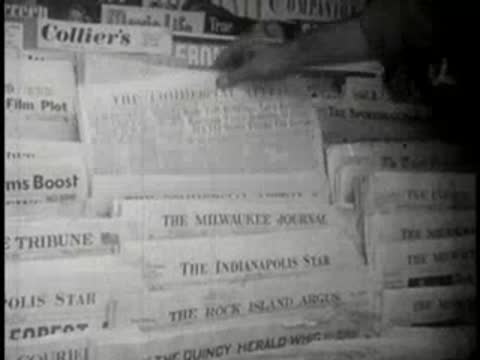 Close-up view of hands organizing and pulling newspapers from a display.