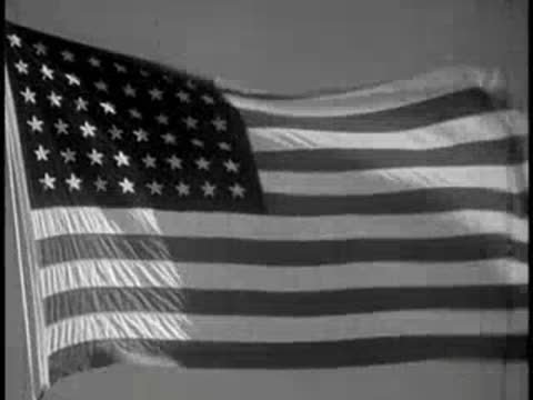 An American flag waving against a bright sky.