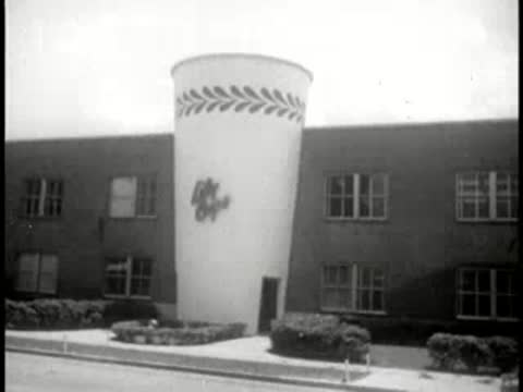 A large novelty cup structure shaped like a Lily Cup outside a building.