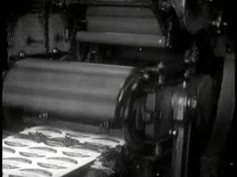 Industrial printing machinery printing graphics on paper sheets.