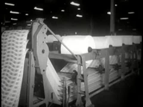 Large industrial machinery processing paper rolls in a manufacturing plant.