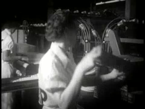 A female worker in uniform handling packaged paper cups in a factory.