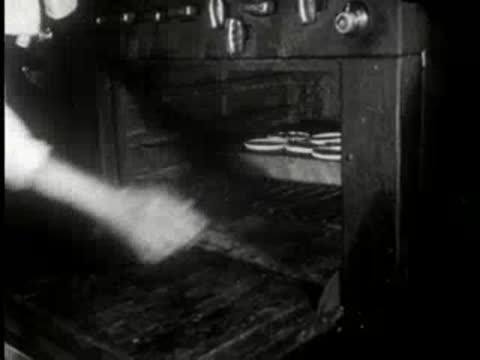baker sliding a tray of pies into a large commercial oven